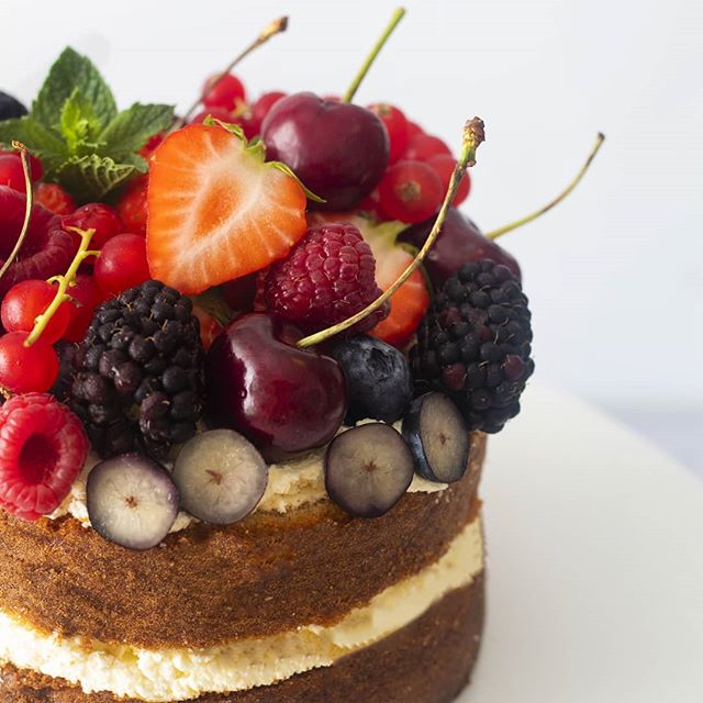 Cake decorated with cherries, strawberries, redcurrants, raspberries, blackberries, mint, blueberries and icing