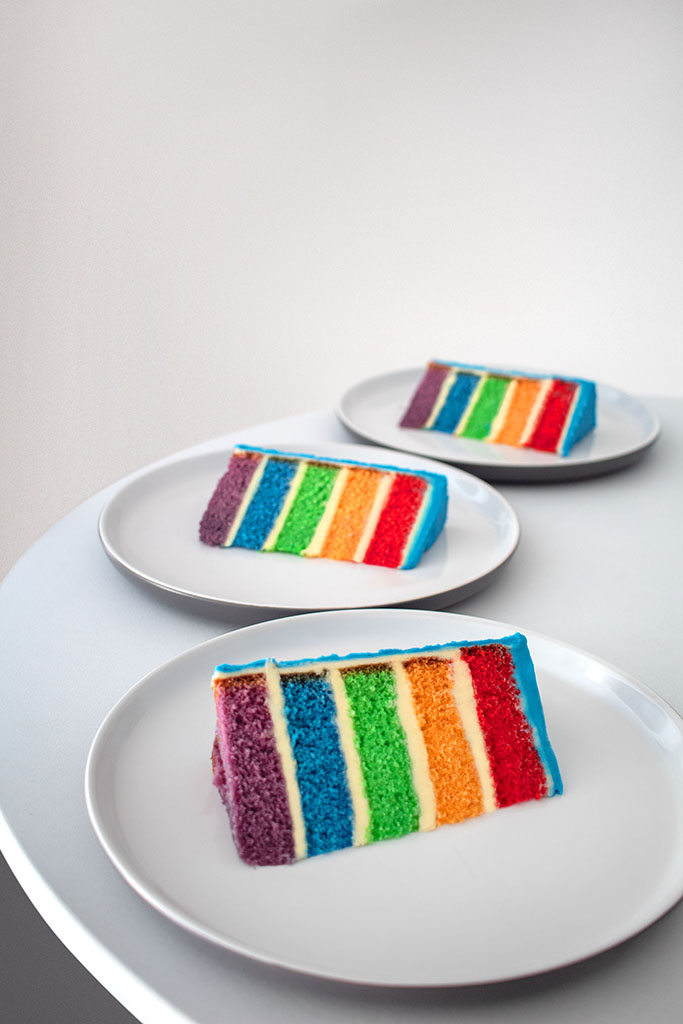 Rainbow cake slices on white plates