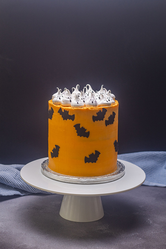 Spooky orange halloween cake with sugar bats and ghosts