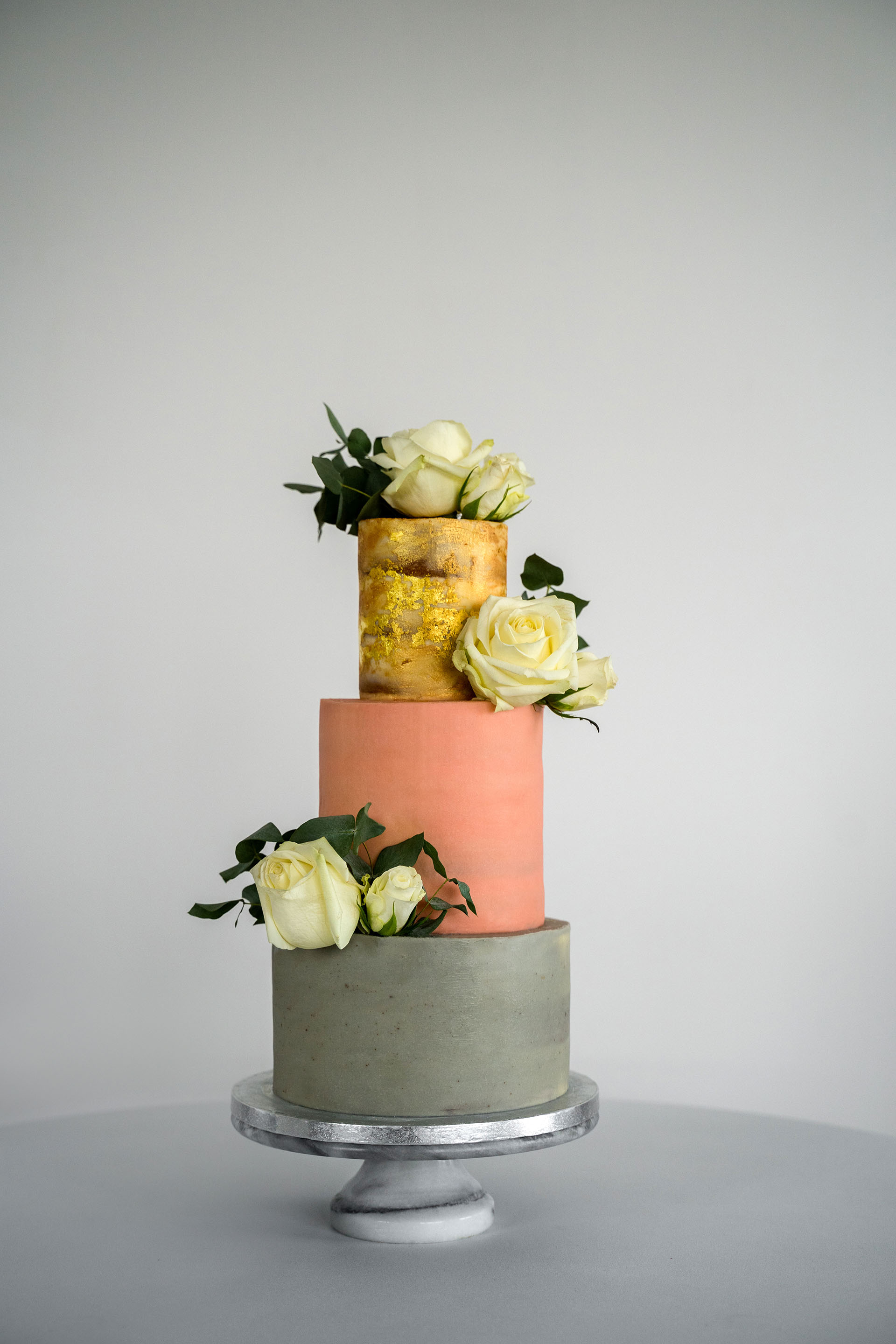 A three-tier wedding cake with flower decorations