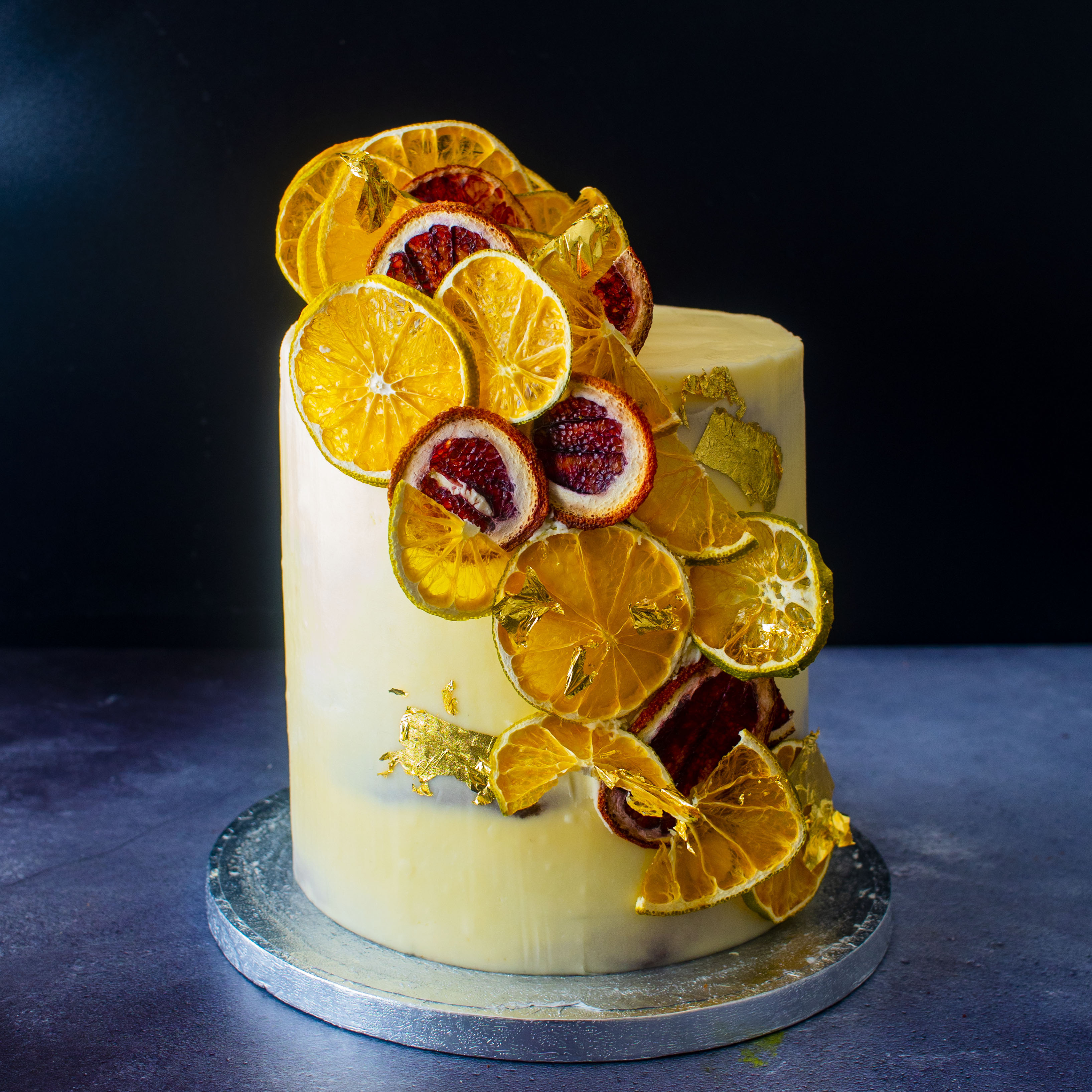 White icing cake with crystalized blood orange and pomegranate